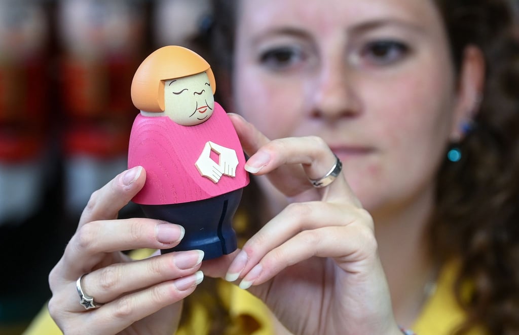 Sina Klement komplettiert in der Schauwerkstatt der Seiffener Volkskunst in Seiffen eine Merkel-Figur.