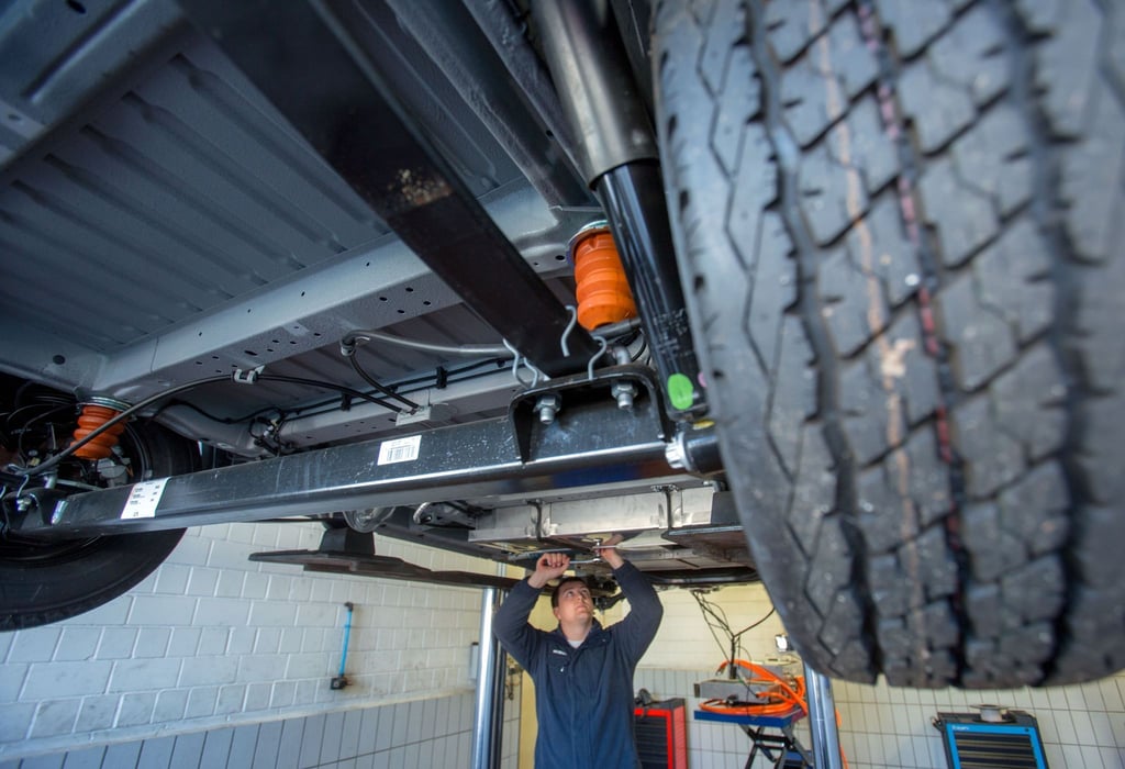 Ein Mechaniker montiert Batterieblöcke in einer Autowerkstatt.