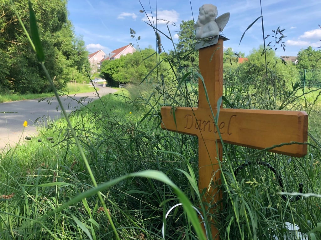 Ein Holzkreuz erinnert an den Mann, der im Sommer 2020 auf seinem Rad angegriffen und getötet wurde.