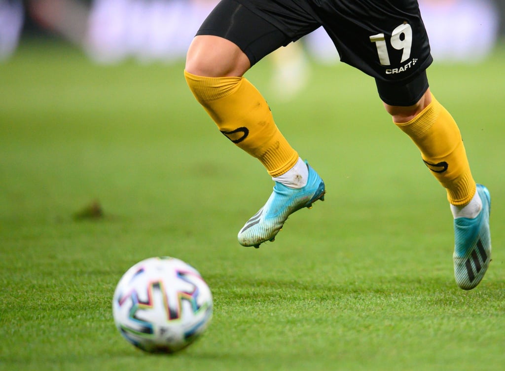 Ein Fußballspieler spielt den Ball.