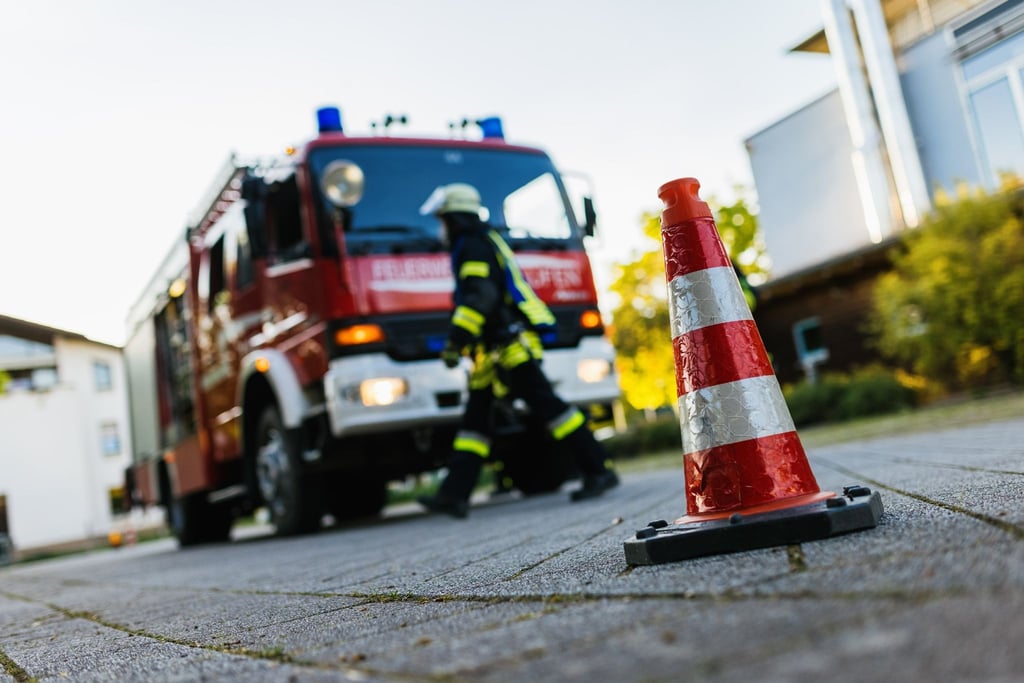 Ein Feuerwehrmann geht an einem Einsatzfahrzeug vorbei.