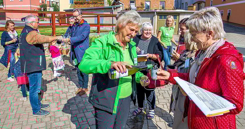Vor dem Vereinshaus schenkt Manuela Frenzel an Jury-Mitglied Petra Schmidt Wein aus.