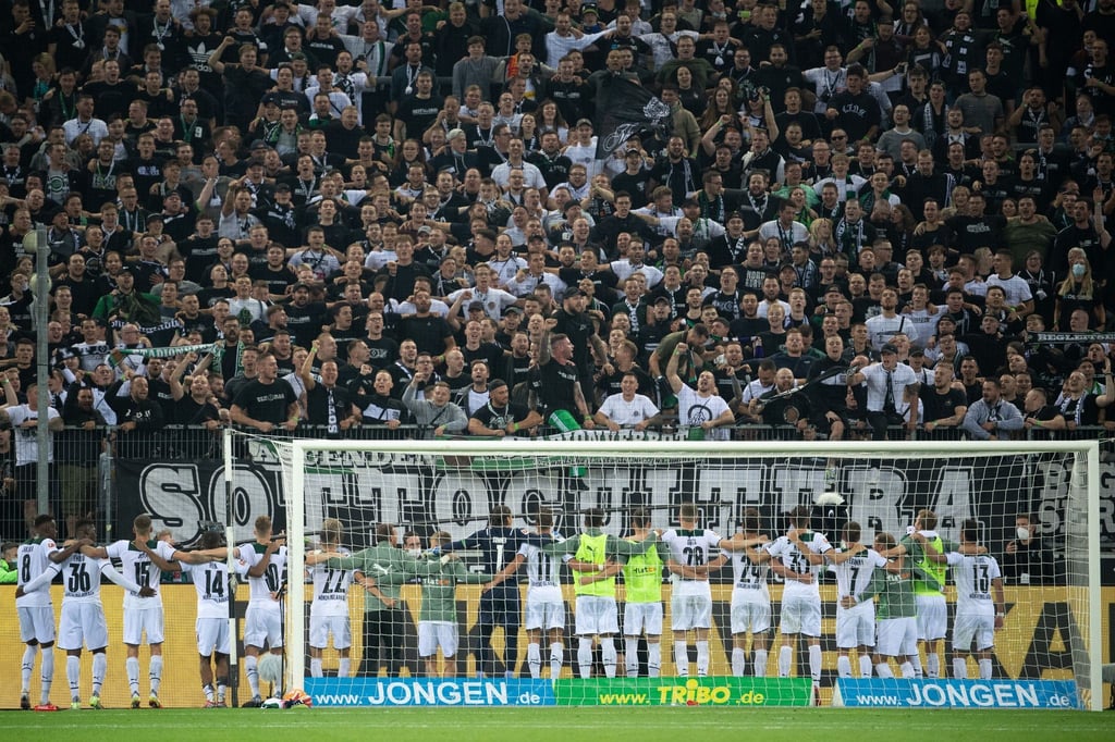 Mönchengladbachs Mannschaft feiert einen Sieg mit den Fans.