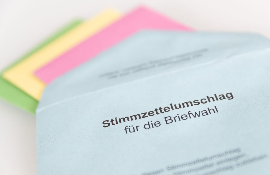Verschiedene Stimmzettel stecken in einem Stimmzettelumschlag zur Briefwahl.