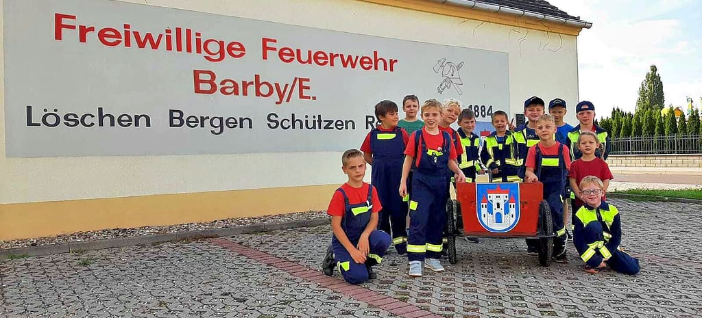 Die Löschbiber vor ihrer Hydrantenkontrolle vor dem Logo der Freiwilligen Feuerwehr Barby. Der mittlerweile verstorbene Malermeister Werner Kropf malte es vor Jahren an die Fassade.
