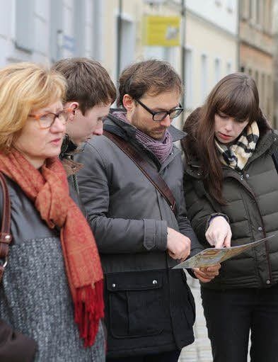 Interessiert betrachten Besucher Baupläne der Stadt.
