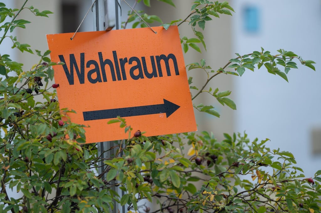 Ein Schild mit der Aufschrift "Wahlraum" zeigt den Weg zu einem Wahllokal.