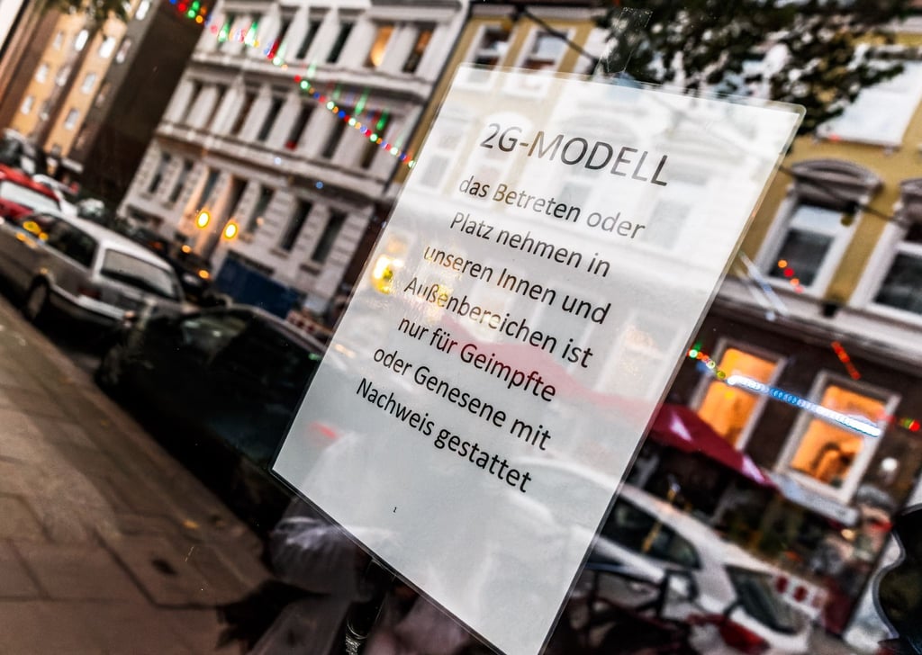 Im Fenster einer Kiez-Kneipe hängt ein Zettel, welcher auf das 2-G Modell hinweist.