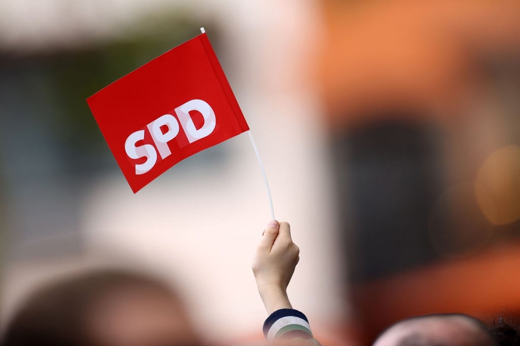 Ein Unterstützer schwenkt bei einer Wahlkampfveranstaltung ein SPD-Fähnchen.