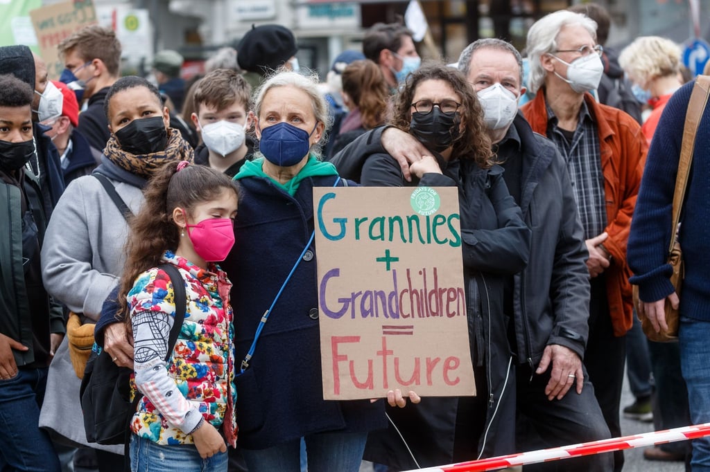 Demonstrantinnen halten ein Schild mit der Aufschrift „Grannies + Grandchildren = Future“.