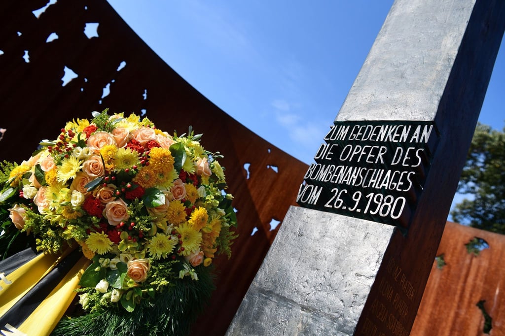 Blumen stehen neben dem Denkmal für das Oktoberfest-Attentat.