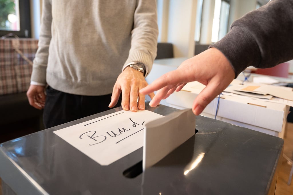 Eine Frau wirft in einem Wahllokal ihren Wahlzettel für die Bundestagswahl in eine Urne.