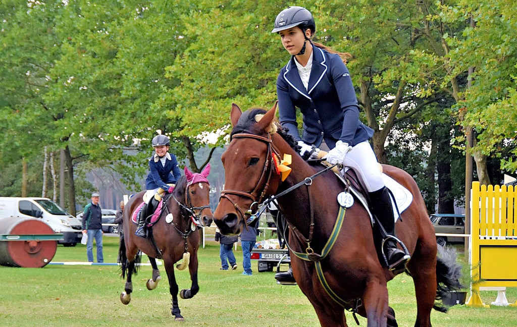 Melina Schlee vom RV Rätzlingen hat mit ihrem Pferd Trinity ZA das Mini-E-Springen gewonnen und führt die Ehrenrunde an. Auf Platz zwei folgt ihr Charlene-Heike Friedl von der PSG Storchenhof in Schwülper auf dem Rücken von Anne Belle.