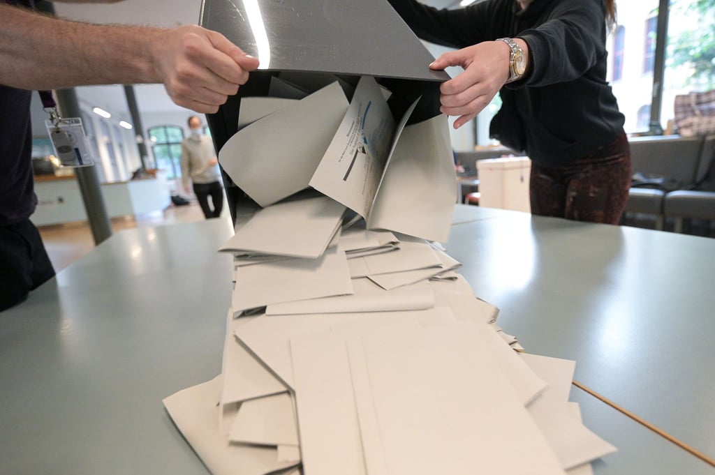Wahlhelfer schütten in einem Wahllokal Stimmzettel für die Bundestagswahl aus.