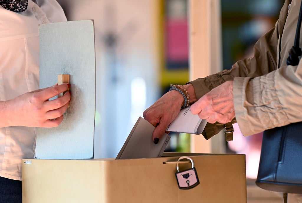 Eine Frau gibt in einem Wahllokal ihren Stimmzettel für die Bundestagswahl ab.