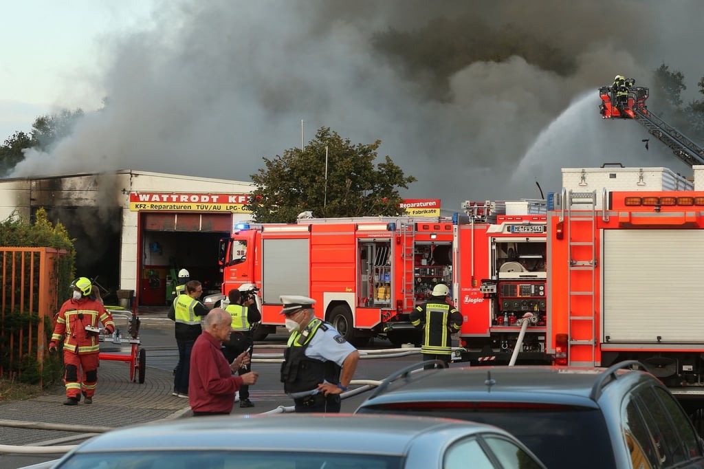 Feuerwehrleute versuchen, einen Brand in einer Kfz-Werkstatt zu löschen.