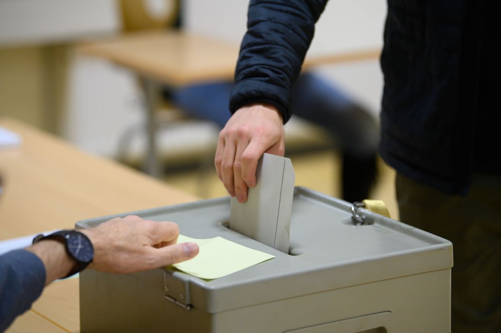 Ein Wähler wirft im Wahllokal seinen Stimmzettel in eine Wahlurne.