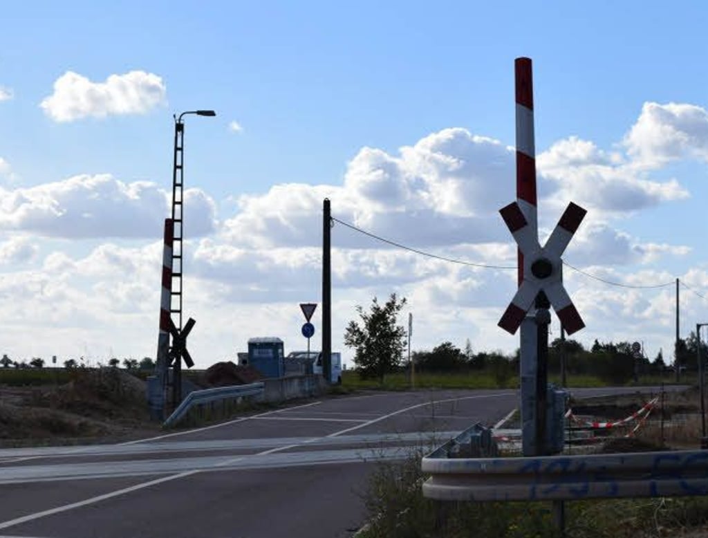 Geöffnete Halbschranken an einem Bahnübergang