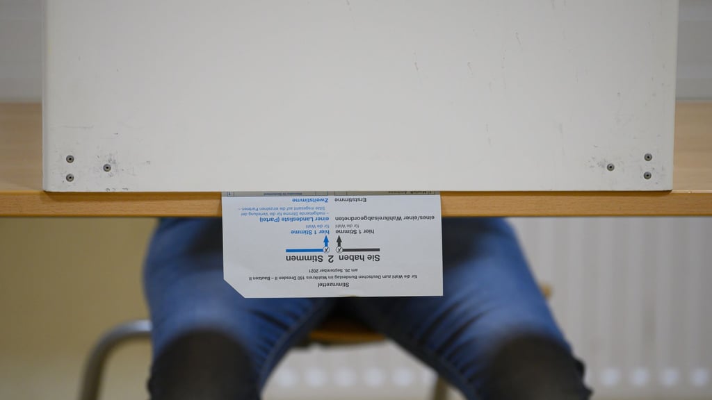 Ein Wählerin sitzt bei der Stimmabgabe zur Bundestagswahl in einer Wahlkabine.