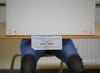 Ein Wählerin sitzt bei der Stimmabgabe zur Bundestagswahl in einer Wahlkabine.