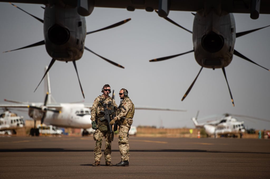 Deutsche Soldaten stehen am Flughafen in Gao und sichern ein Transportflugzeug.