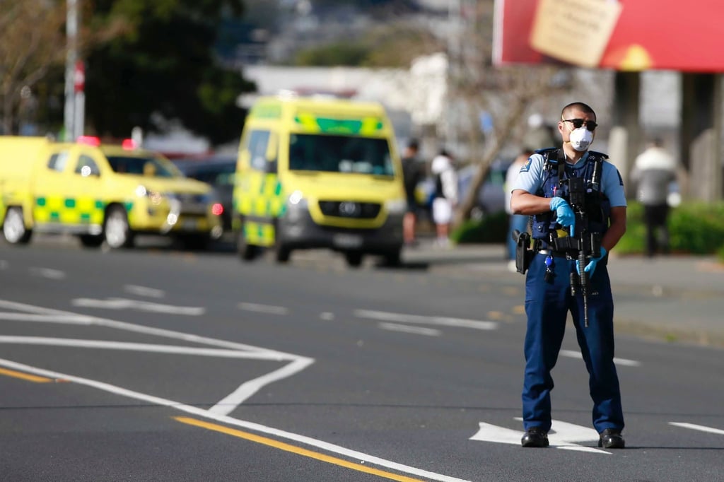 Ein Polizist steht vor dem Supermarkt in Auckland, in dem es zu dem Angriff kam.