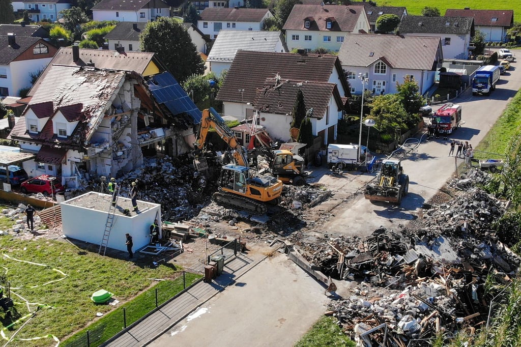 Zwei Bagger und ein Radlader sind bei Bergungsarbeiten an den Überresten des Hauses im Einsatz.