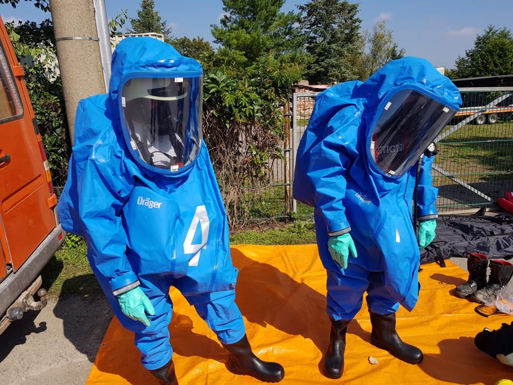 Nur mit ABC-Schutzanzügen dürfen sich die Kameraden der Feuerwehr der orange-gelben Wolke näher