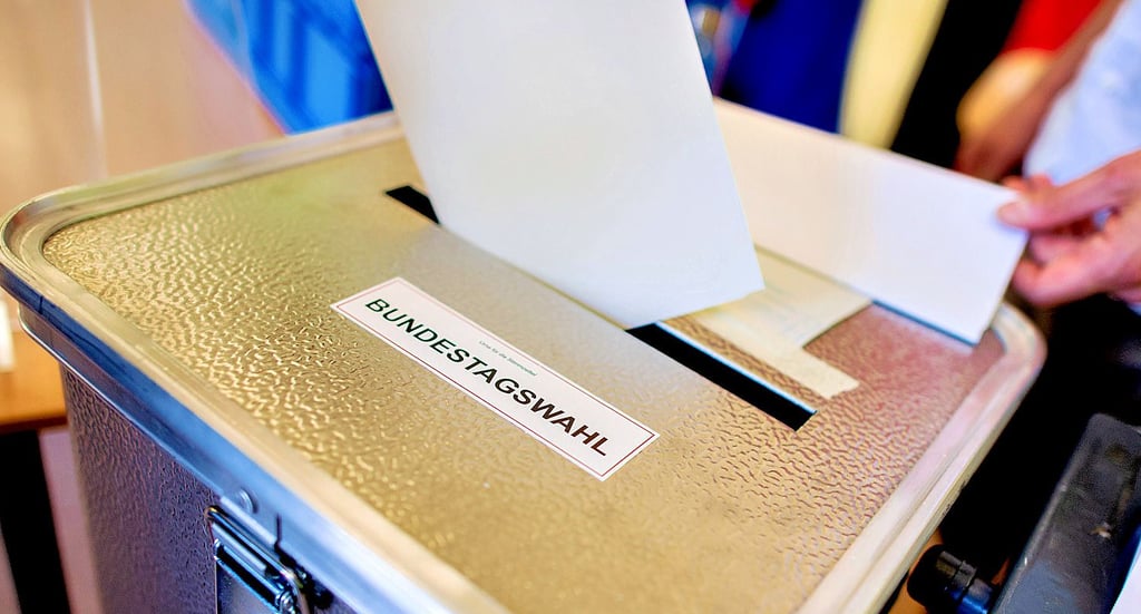 Ein Stimmzettel wird in eine Wahlurne geschoben.