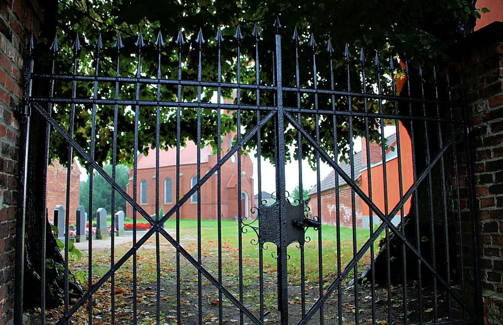 Hinterm Tor verbirgt sich die sanierte Kirche von Pulspforde. Sie gehört zu den entschlossenen Kirchen.