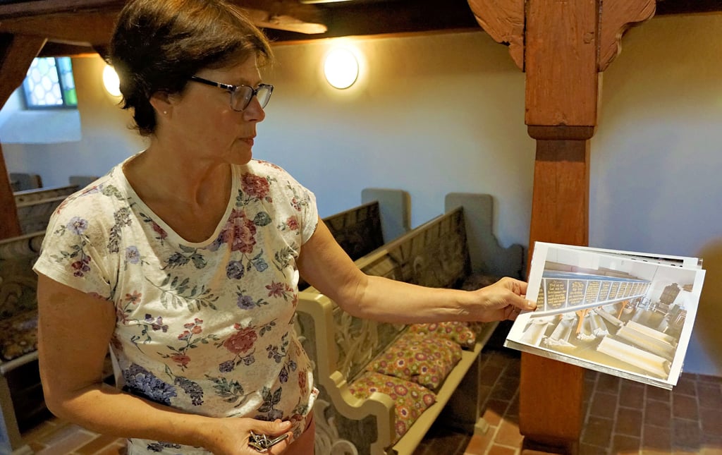 Elisabeth Wünsch zeigt an Hand alter Aufnahmen, wie das Hochwasser die Kirche schädigte: ?Die Kirchenbänke schwammen wie kleine Schiffe durch den Chor."