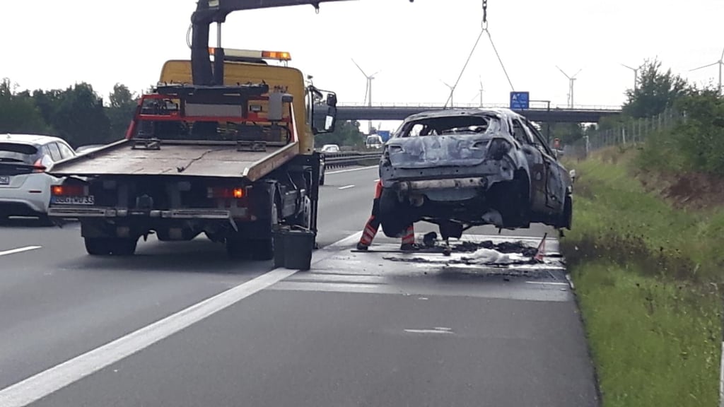 Das ausgebrannte Hybridauto wird auf der A14 geborgen.