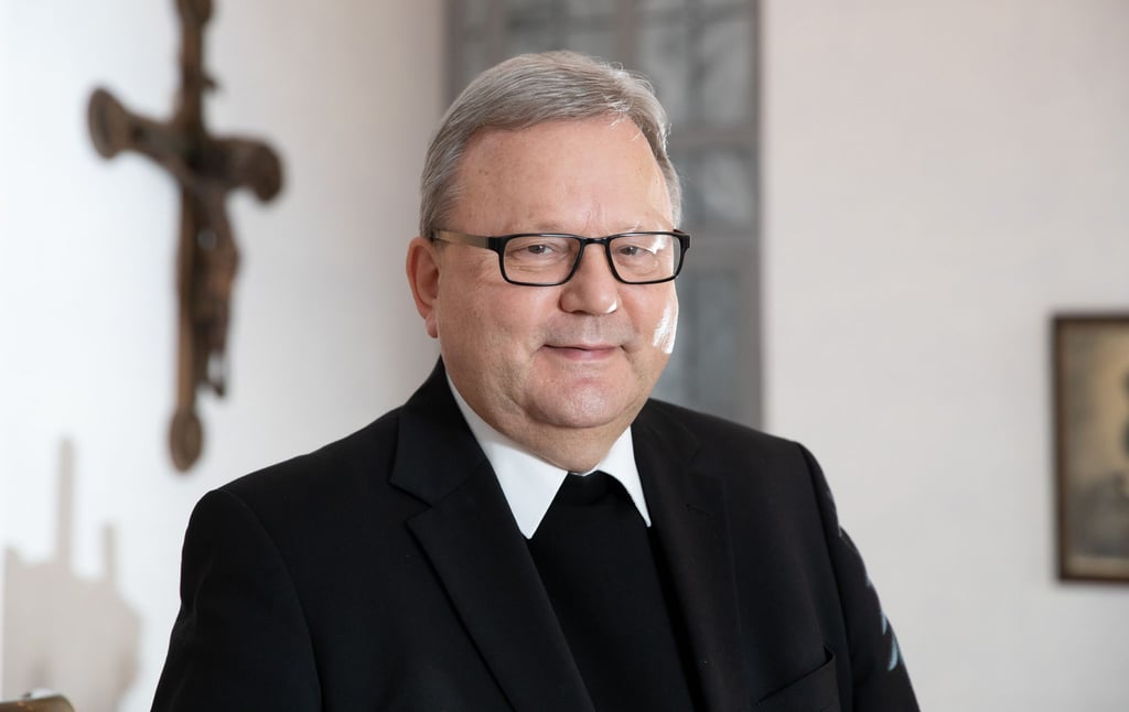 Franz-Josef Bode, Bischof des Bistums Osnabrück, steht im Bischofshaus vor einem Kreuz.
