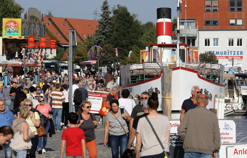 Besucher sind bei der Müritz Sail im Stadthafen unterwegs.