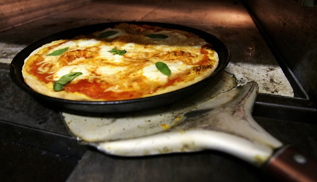 Eine Pizza wird zubereitet.