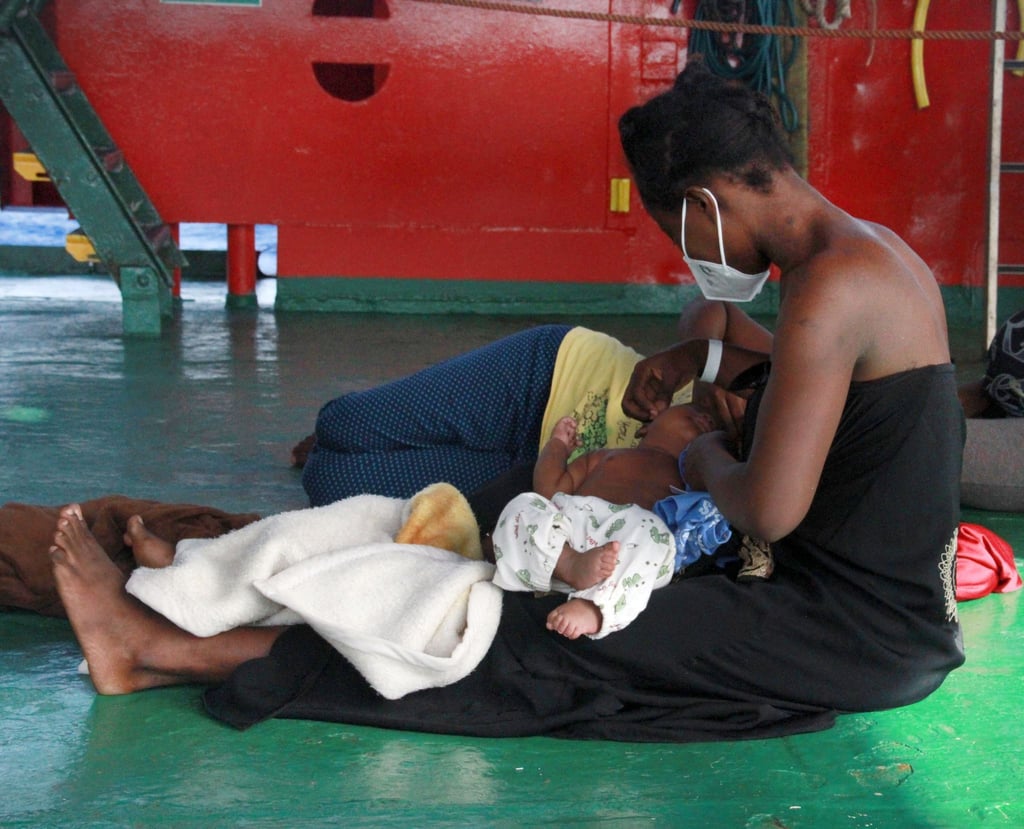 Eine Frau sitzt mit ihren Kindern an Deck des Seenotrettungsschiffs „Sea-Eye 4“.