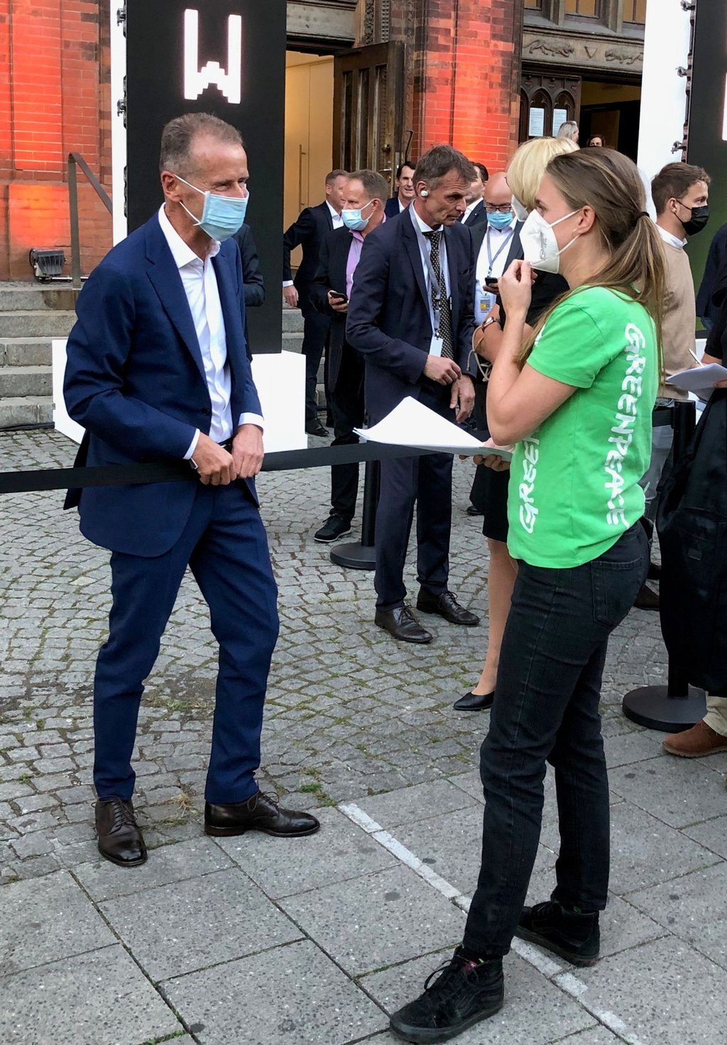 Die Greenpeace-Verkehrsexpertin Marion Tiemann übergibt VW-Vorstandschef Herbert Diess die Klageschrift.