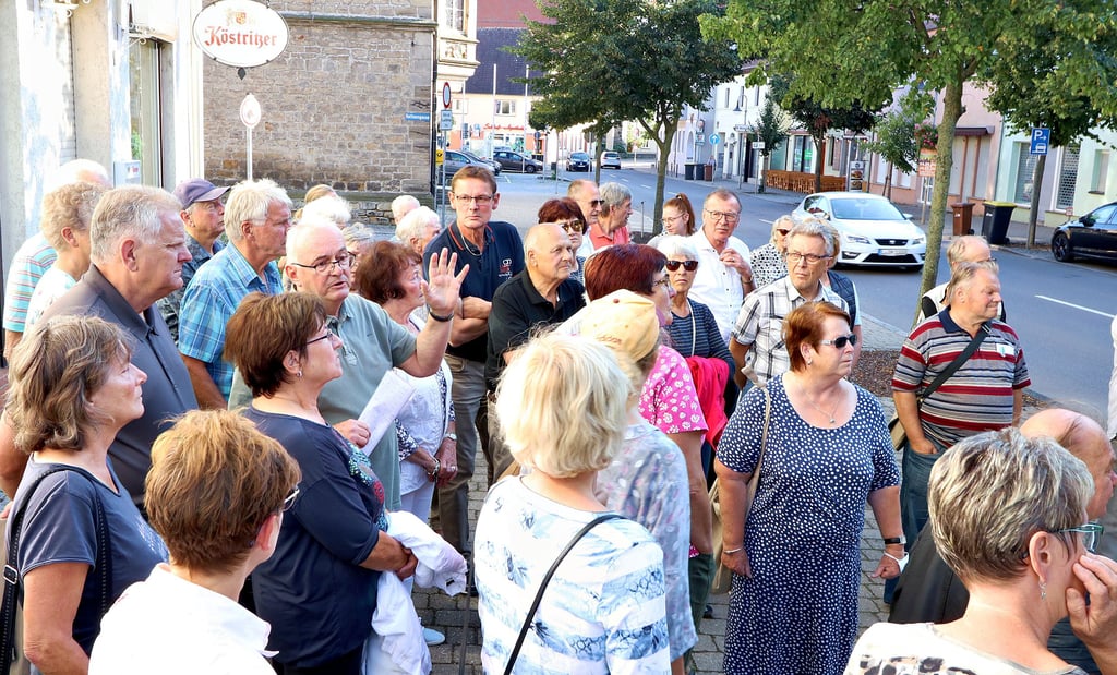 Hans-Georg Walther (linke Bildmitte) erläutert den interessierten Lützenern beim Stadtrundgang die Historie hinter den Häusern ihrer Stadt.