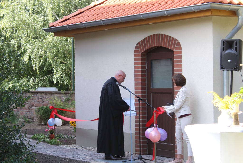 Das Toilettenhäuschen auf dem Gelände der Marienkirche wird von Superintendent Uwe Jauch und Kirchenälteste Daniela Gellert symbolisch freigegeben.