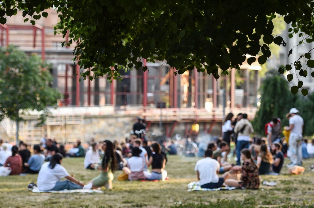 Menschen sitzen bei schönem Wetter im James-Simon-Park.