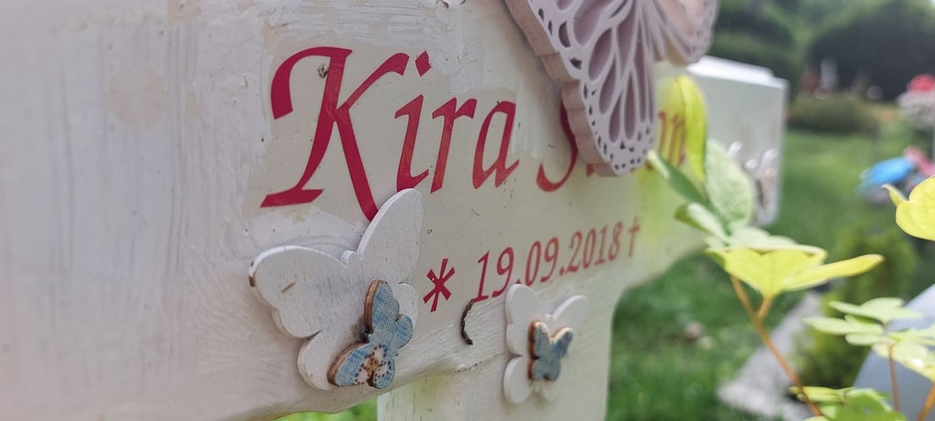 Kiras Grabstein auf dem Friedhof - Geburts- und Sterbedatum fallen auf einen Tag.
