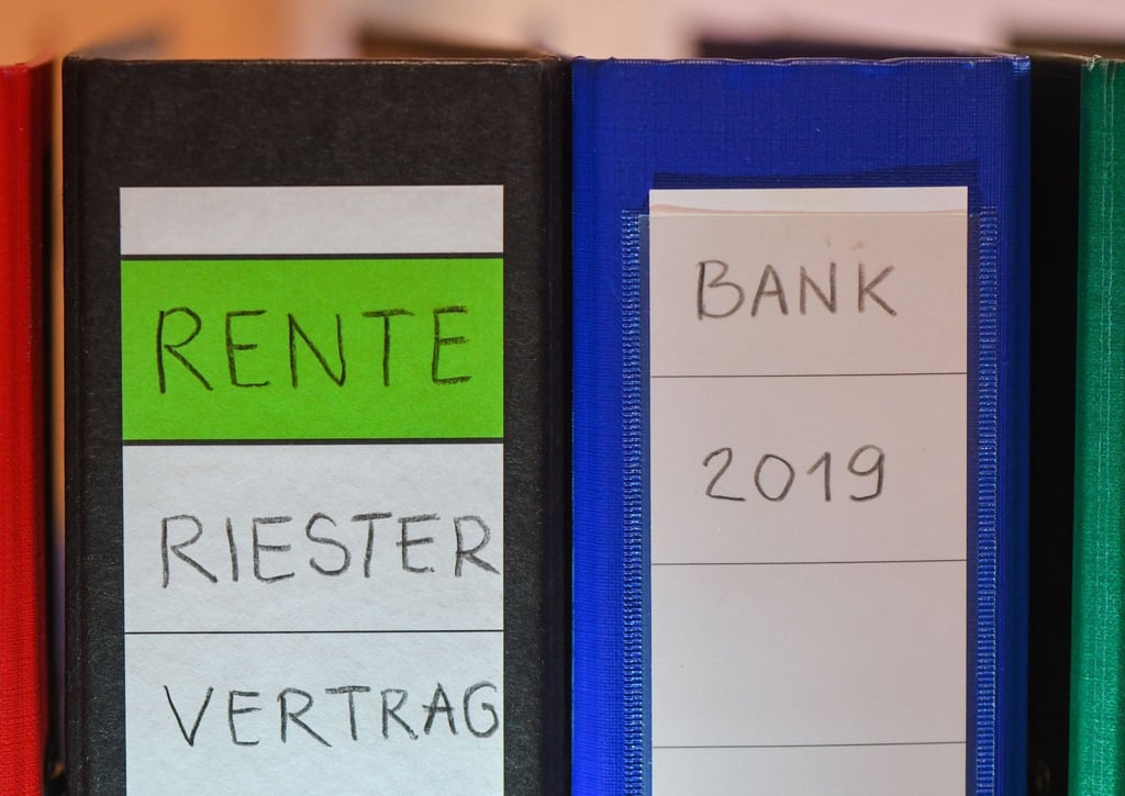 Ein Ordner mit der Aufschrift „Rente Riester Vertrag“ steht zwischen anderen Aktenordnern.