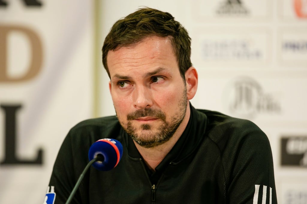 Kiels Sportlicher Leiter, Viktor Szilagyi, sitzt vor einem Mikrofon.