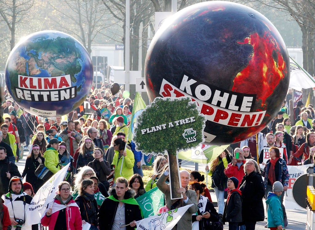 Demonstranten fordern in Bonn mit einem Modell der Erdkugel mit der Aufschrift "Klima retten" und einer weiteren mit der Aufschrift "Kohle stoppen" die Umsetzung des Weltklimaabkommens.