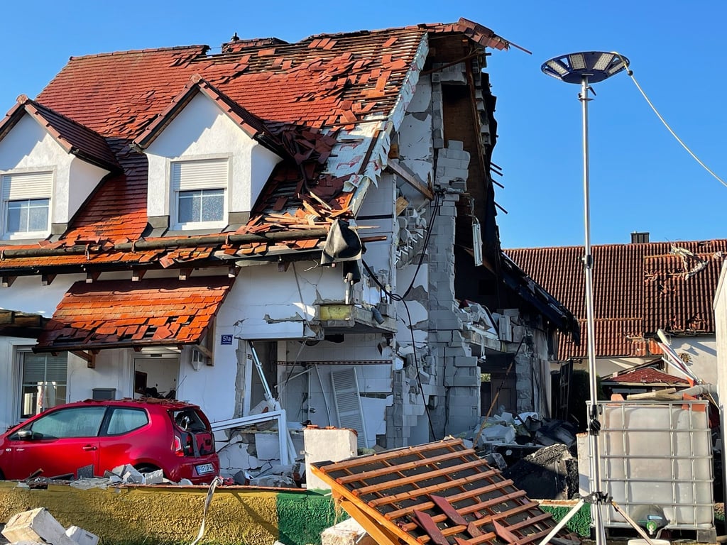 Nach der Explosion eines Wohnhauses ist das Nachbarhaus von Beschädigungen schwer gezeichnet.
