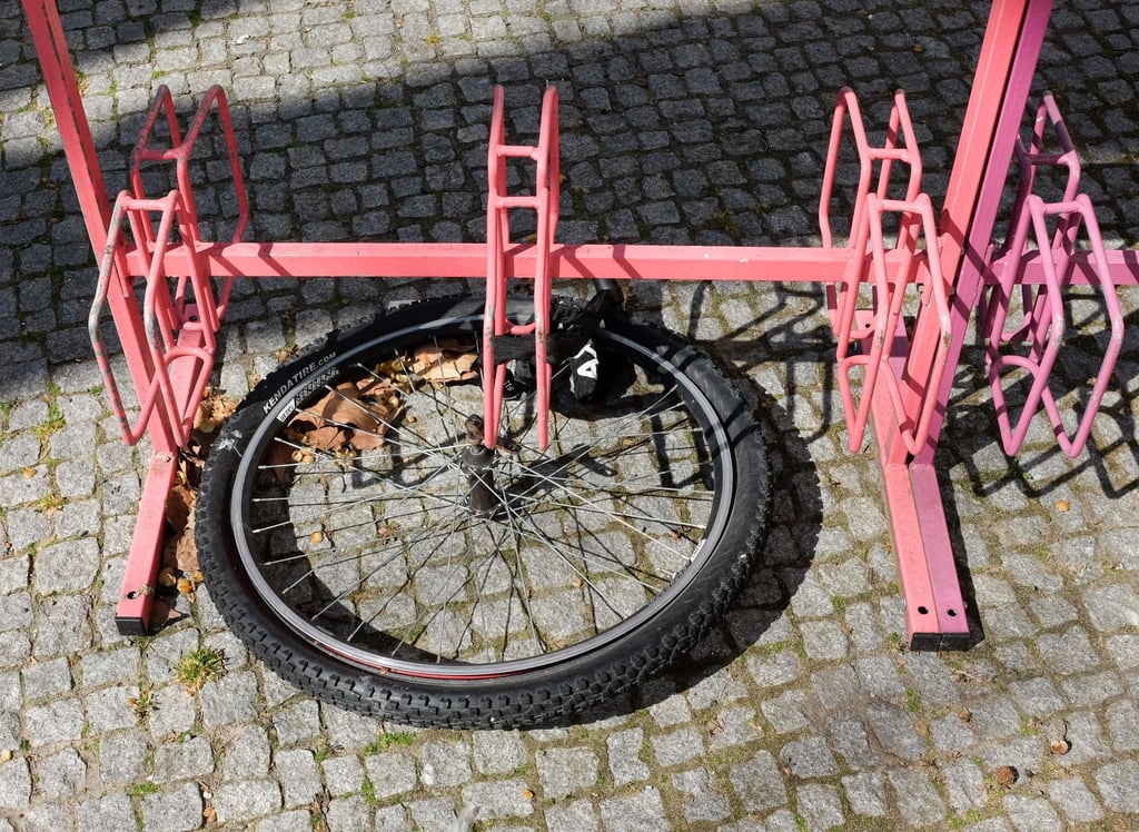Nur noch das Vorderrad eines Fahrrads ist an einem Fahrradständer angeschlossen.