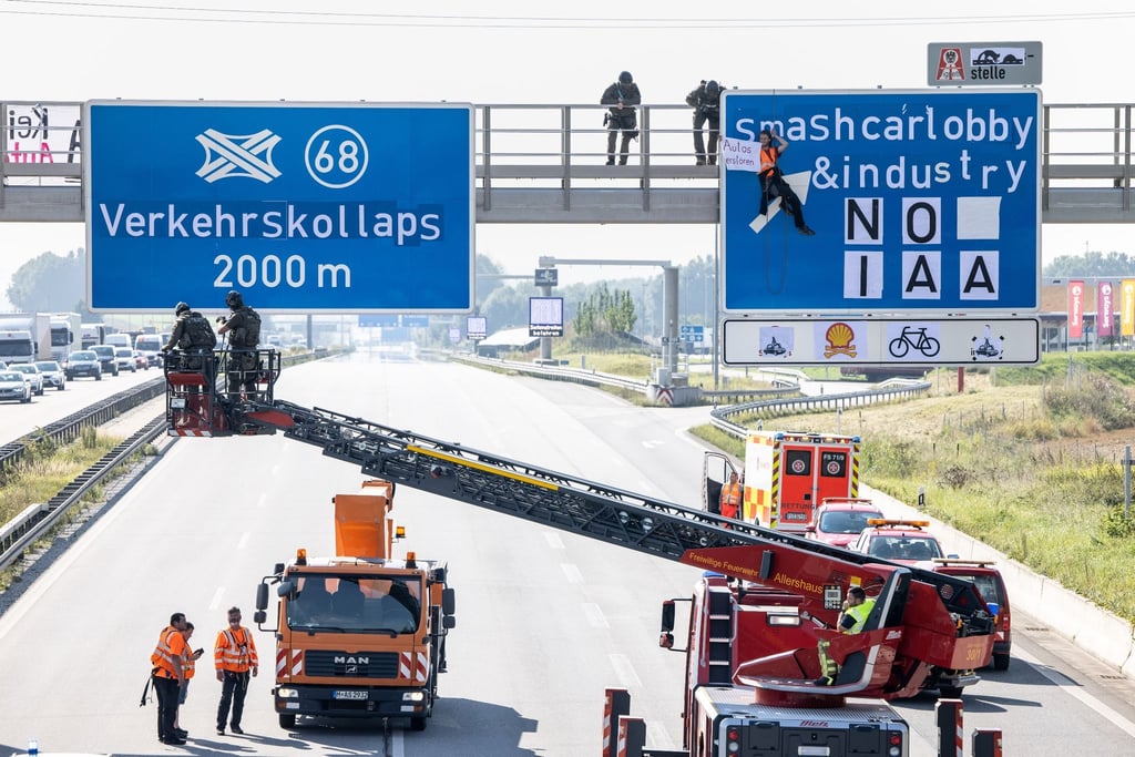 Ein Aktivist hängt während einer Banneraktion an einer Schilderbrücke über der Autobahn A9 bei Fürholzen in Fahrtrichtung München.