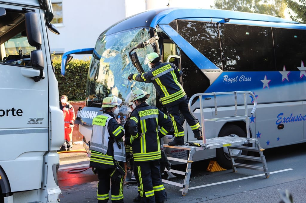Einsatzkräfte stehen nach einem Zusammenprall zwischen einem beschädigten Lastwagen und einem Bus. Bei einem schweren Verkehrsunfall sind mindestens zwölf Menschen verletzt worden.