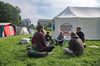 Umweltaktivisten sitzen im Regierungsviertel zusammen vor einem Zelt.