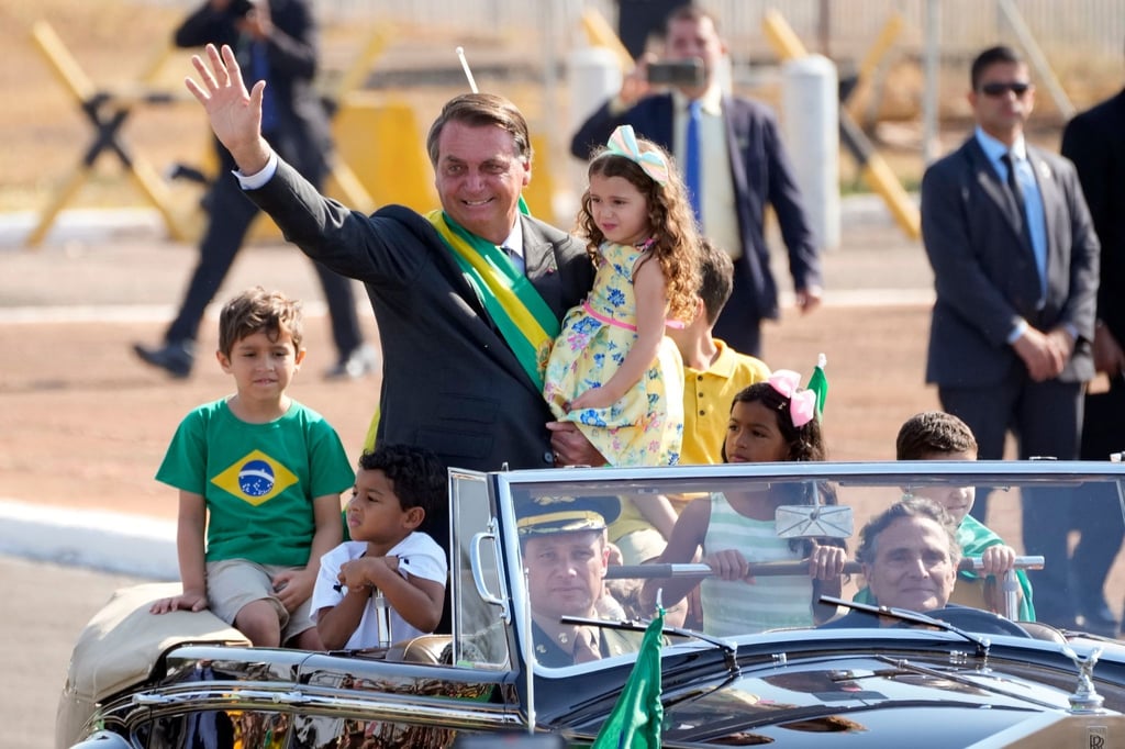 Jair Bolsonaro (M) kommt zu einer Flaggenhissungszeremonie in der Präsidentenresidenz.